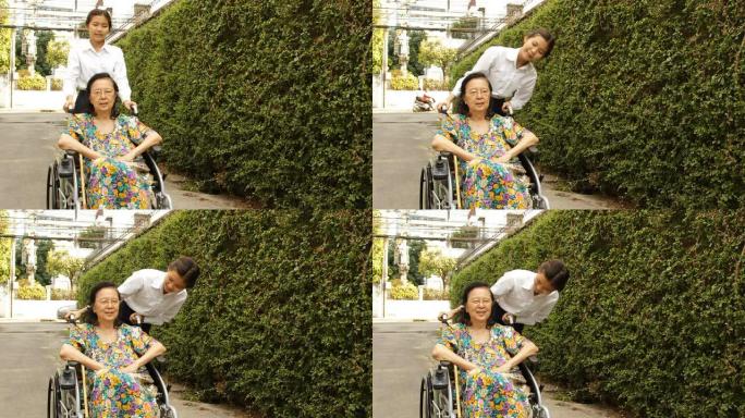 年轻的看护人帮助坐在轮椅上的老年妇女