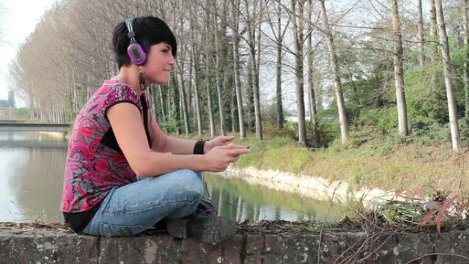 年轻女子用耳机听音乐