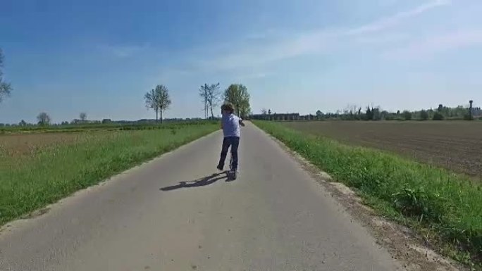 乡村公路上的儿童骑踏板车