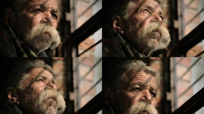 大胡子的老人从窗户向外看。