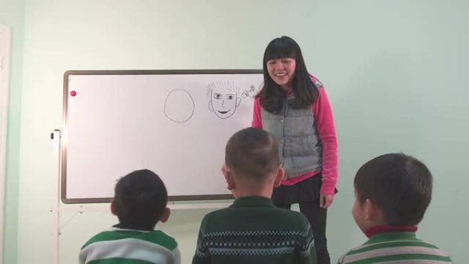 亚洲幼儿教师教孩子在黑板上画画