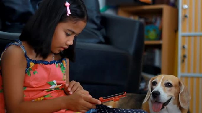 非洲小女孩在用平板电脑，她的小猎犬在看平板电脑