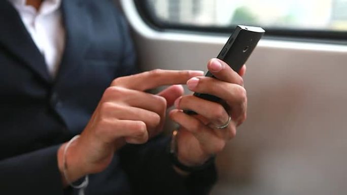 高清：商人在火车上玩手机的手。