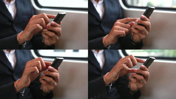 高清：商人在火车上玩手机的手。