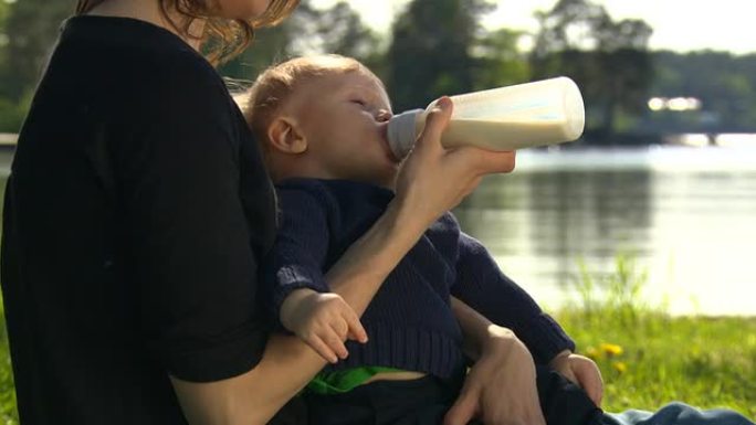 母亲带着孩子，用奶瓶喝水，奶嘴。