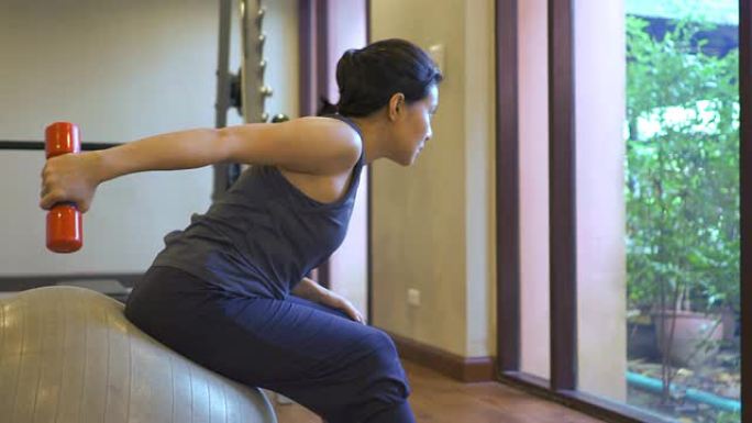 女人在健身房锻炼摆臂背部肌肉建设肱二头肌