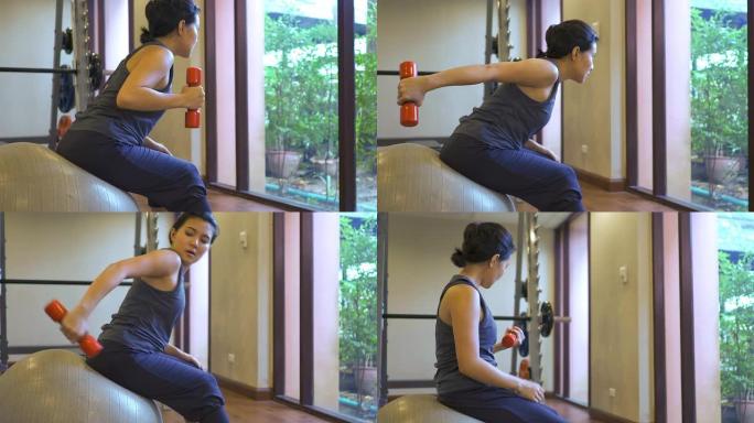 女人在健身房锻炼摆臂背部肌肉建设肱二头肌