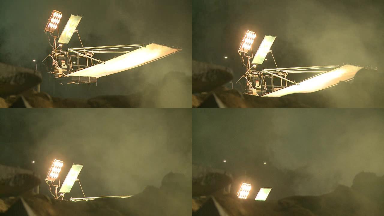 明亮的电影设置灯光起重机和移动通过特殊效果雾在晚上