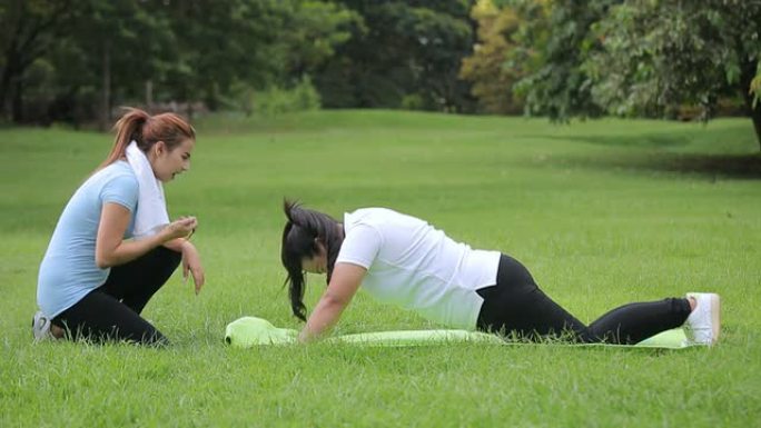 年轻的亚洲女性与私人教练一起锻炼