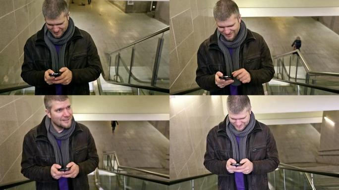 一名年轻男子在自动扶梯上拿着智能手机