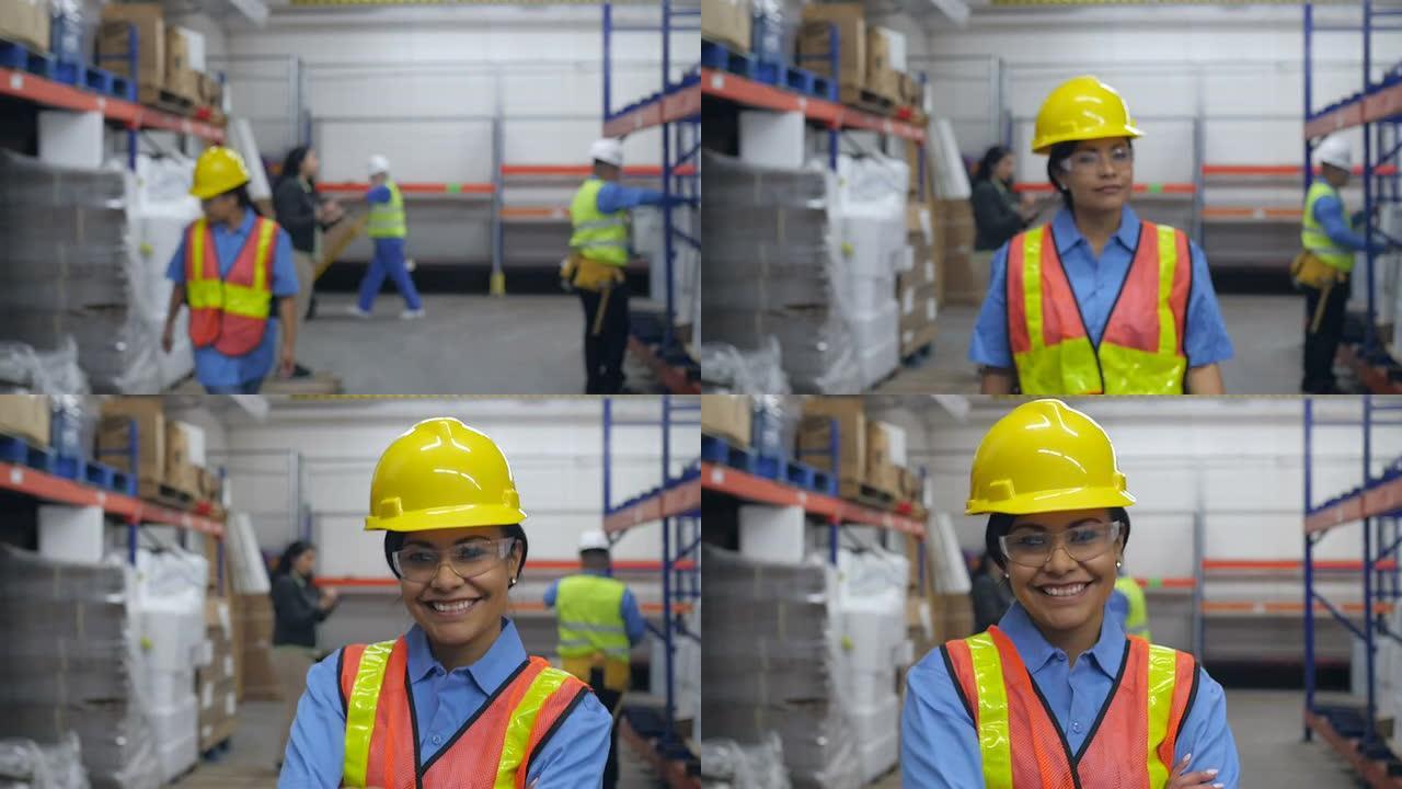 在仓库工作的西班牙裔妇女走进镜头，对着镜头微笑