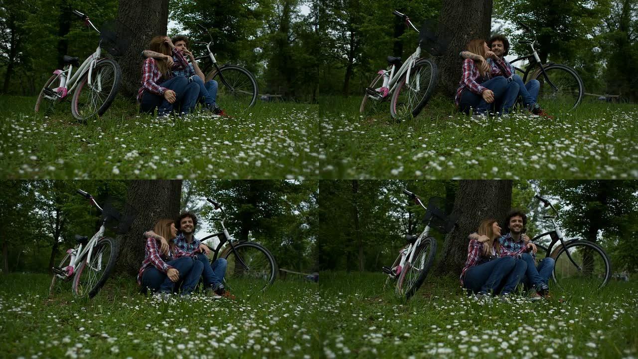 高清: 年轻夫妇在户外骑自行车后享受休息。