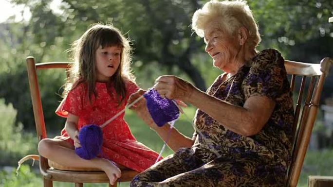 一个小女孩从祖母那里学习编织