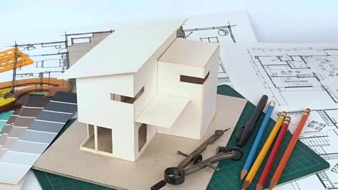 带有房屋模型和蓝图的建筑师工作区