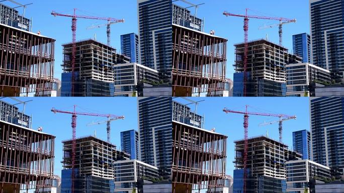 正常速度的两台大型建筑起重机在德克萨斯州奥斯汀市中心的摩天大楼建筑上