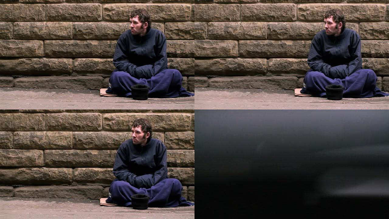 一个无家可归的男人坐在街上乞讨