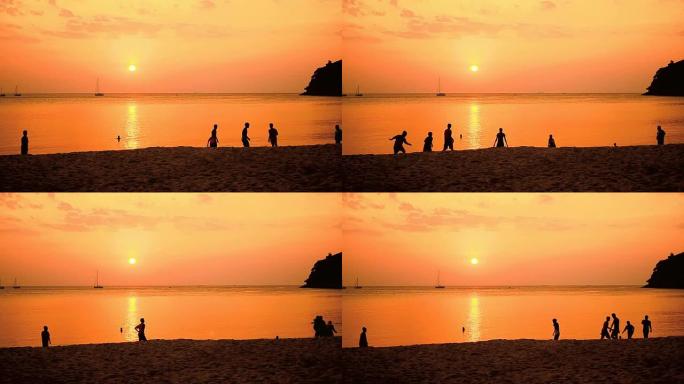 孩子们在日落的海滩上踢足球