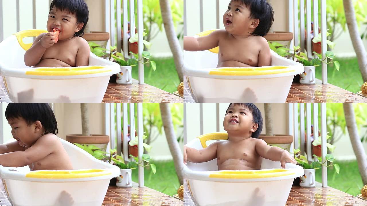 可爱的小男孩在浴缸里户外洗澡