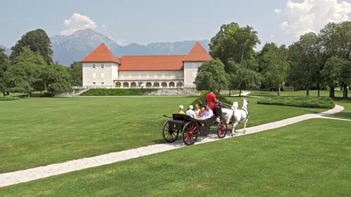 乘坐马车穿越城堡公园的空中家庭