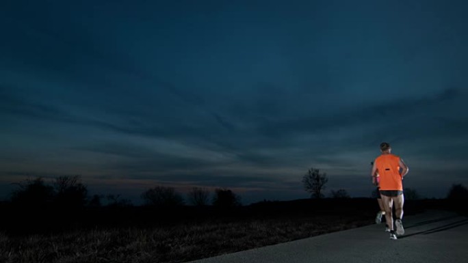 SLO MO夫妇在黄昏时在路上奔跑