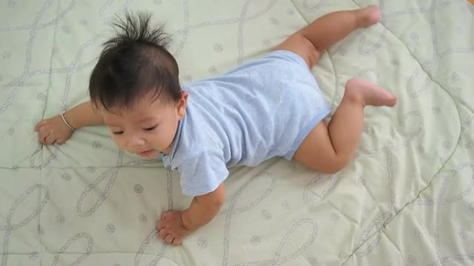 6个月大的婴儿在床上爬行。