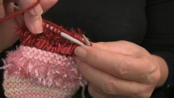 女士手用粉色羊毛编织Purl缝线特写