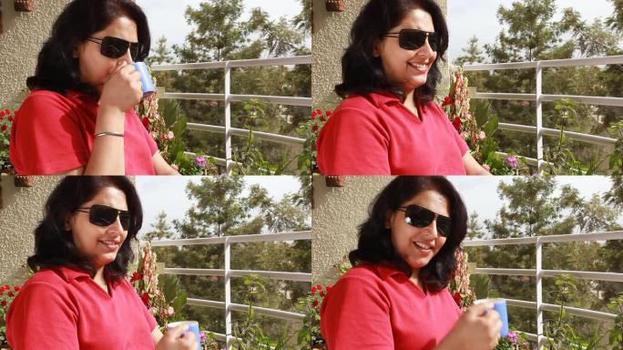 快乐的印度女人啜饮咖啡或茶