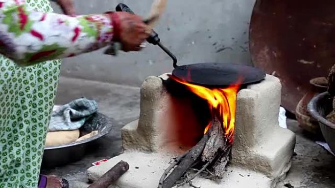 妇女在家在泥炉上做饭