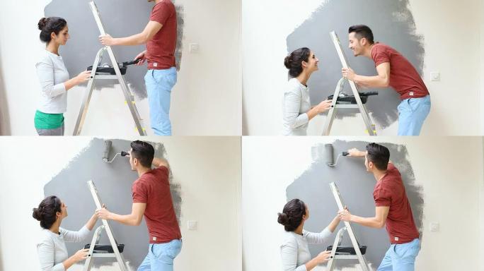 年轻情侣接吻并用油漆滚筒粉刷墙壁