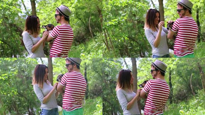 一对可爱的年轻夫妇喜欢和一只可爱的小狗玩耍