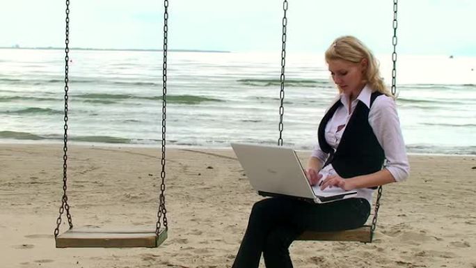 海边带笔记本电脑的漂亮女孩