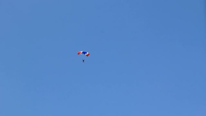 在蓝天下跳伞。