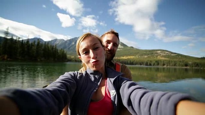 夫妇在山湖边自拍智能手机通话购物自拍短信