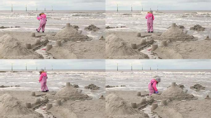 小女孩在海滩上的沙堡里玩耍