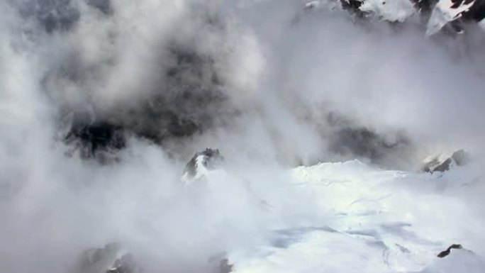 高空摄影盘旋在高山和云中的冰川上