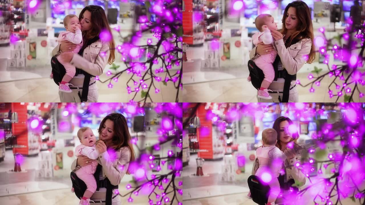 妈妈在购物中心亲吻她的宝宝