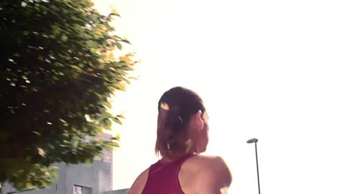 SLO MO TS女性在阳光下在城市中奔跑