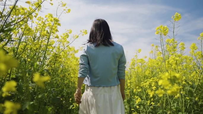 白裙美女田间慢步踏青春游亲近自然微风拂面