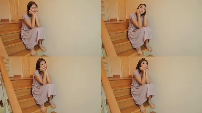 年轻的亚洲女性独自坐在楼梯上