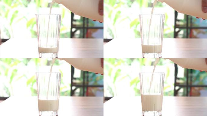 将牛奶倒入玻璃杯中