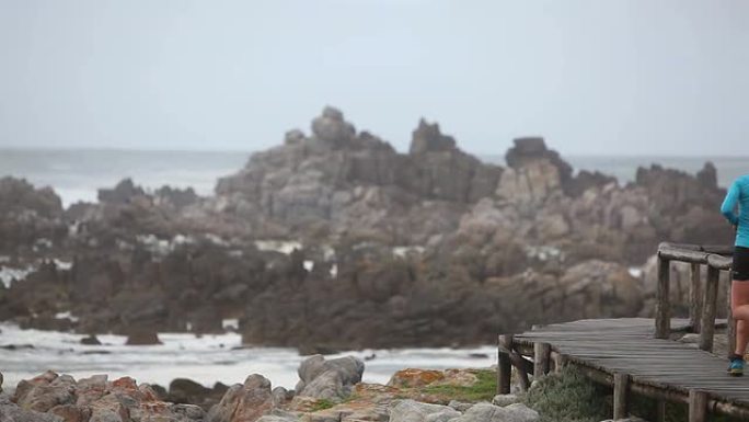 一名女子沿着海边的人行道晨跑