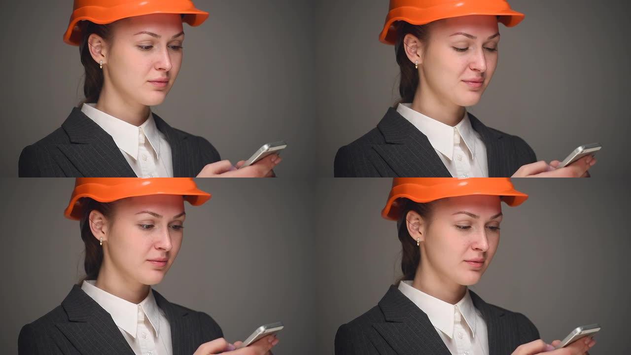 戴着头盔的女商人在手机上打字