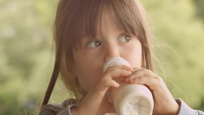 HD-SEQUENCE。孩子在一个美丽的夏日早晨在门廊享受牛奶
