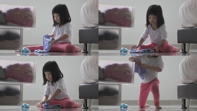 女孩帮忙做家务。折叠衣服，放在抽屉柜里。