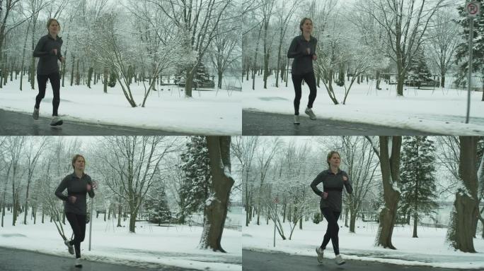 女人在冬天跑步坚持不懈身体管理慢镜头慢动