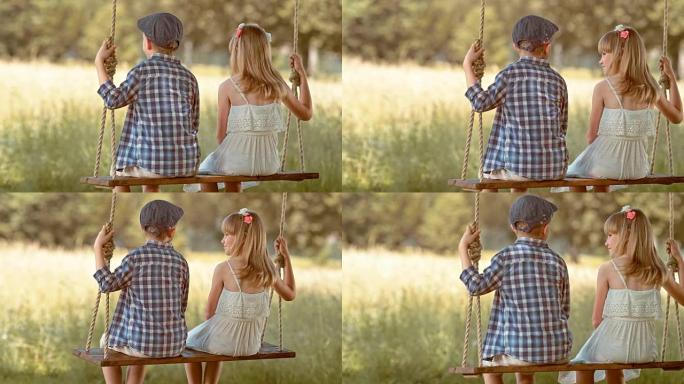 SLO MO男孩和女孩在树下摇摆