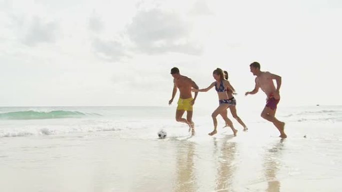 一群年轻人在海滩上踢足球