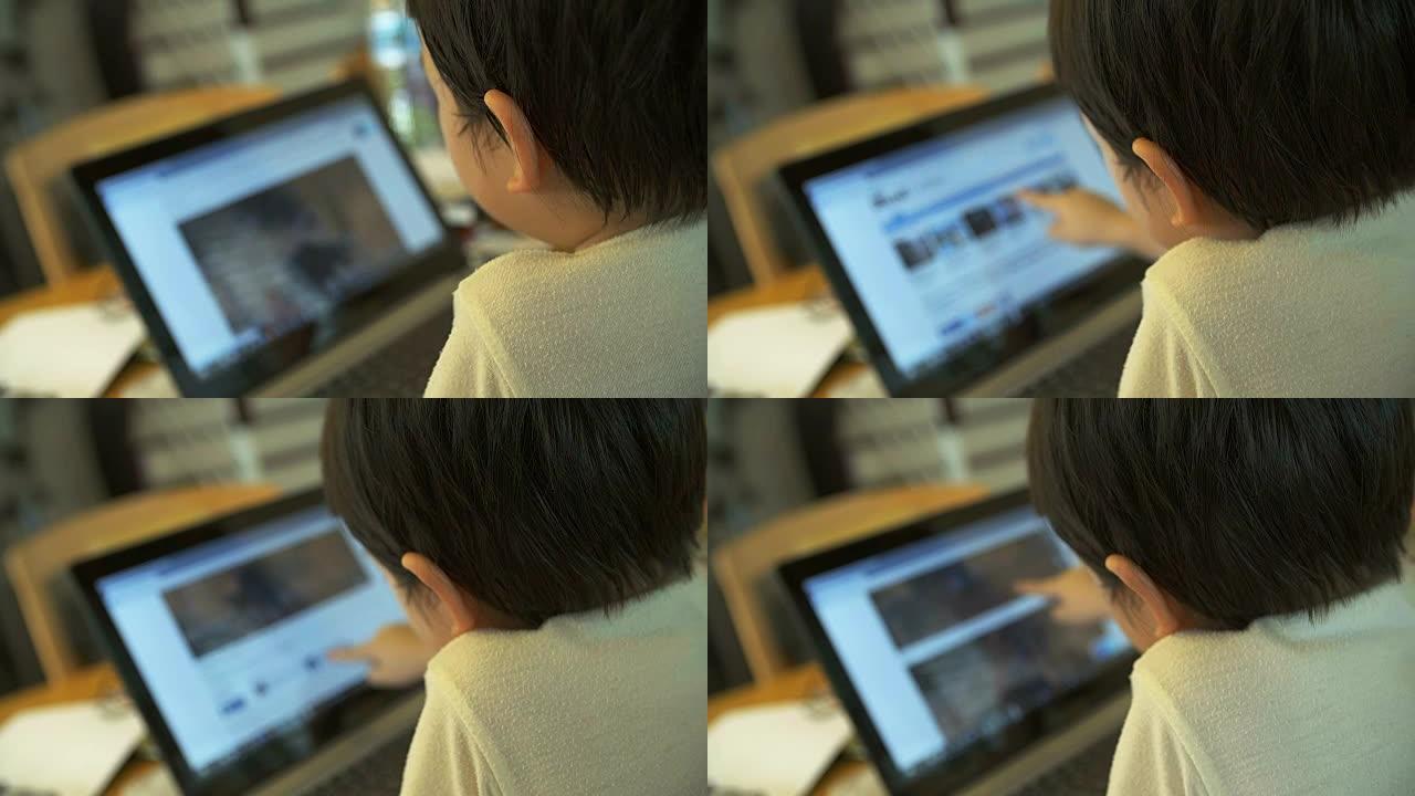 4K: 小男孩使用笔记本触摸屏。