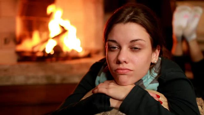 在壁炉旁思考发呆的外国女人燃烧的篝火