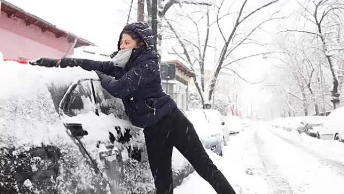 年轻女子清理汽车上的积雪。